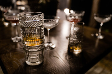 Glasses with alcoholic drink on bar counter. Night party concept