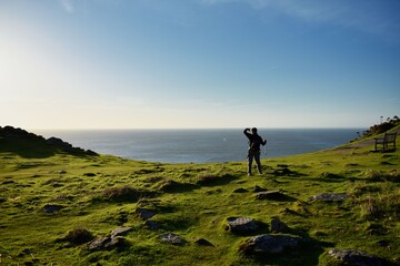 Man looking out to the bright open sea horizon, Valley of the Rocks Exmoor England