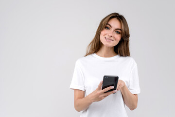 Fototapeta premium Woman wearing a white shirt using a mobile phone isolated on a white background