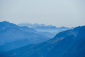 Fototapeta na wymiar blurred abstract natural background with Caucasus Mountains in a morning blue mist
