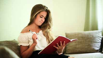 Young woman studying sitting on her sofa in her flat