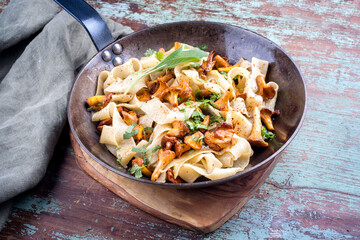 Traditionelle gebratene italienische Tagliatelle con Galletti mit Pilzen angeboten als close-up in einer rustikalen Eisen Pfanne © HLPhoto