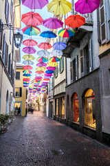 central street of Arona with many colored umbrellas hanging