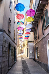 central street of Arona with many colored umbrellas hanging
