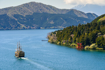 Red torii gate and tourist cruise at Lake Ashi, Hakone