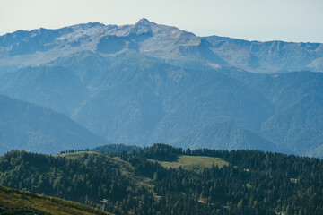 natural wallpaper with high mountains in fog and green hill