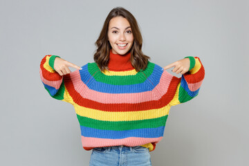 Smiling excited beautiful attractive young brunette woman 20s in casual colorful knitted sweater pointing index fingers on herself looking camera isolated on grey colour background, studio portrait.