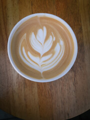 top view fresh coffee with milk foam art on a wooden background