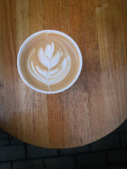 top view fresh coffee with milk foam art on a wooden background