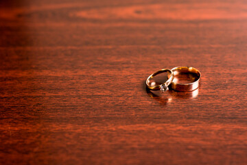 Gold wedding rings on a wooden background.Wedding attributes. Wedding ceremony