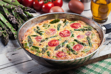 Frittata made of eggs, asparagus and tomatoes - 381162522