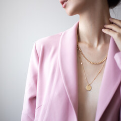 Closeup photo of young woman wearing pink jacket and golden necklace - obrazy, fototapety, plakaty