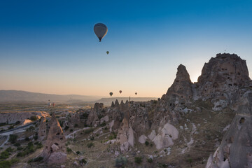 Uchisar castle and town, hot air balloons in sunrise, Cappadocia, Turkey