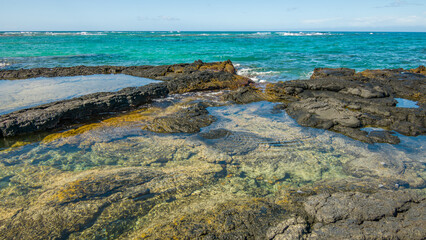 Beautiful shore. Large boulder among the waves in the sea. Hawaii