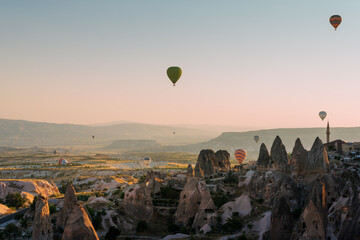 Uchisar castle and town, hot air balloons in sunrise, Cappadocia, Turkey
