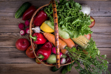 Fresh vegetables and fruits in basket on rustic wooden table
