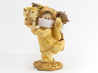 Angel figurine wearing paper mask next in front of white background