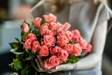 
roses in a bouquet in the hands of a girl in a store