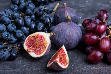 Fresh figs and grapes on dark background