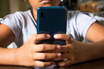 Manos de una niña sujetando un celular