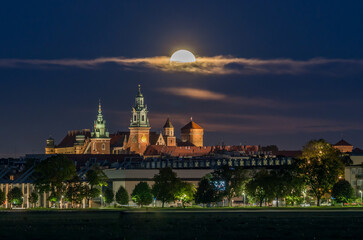 Fototapeta na wymiar Wawel Castle and full moon, Krakow, Poland, seen from Blonia meadow.