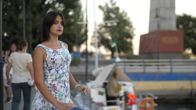 Gorgeous girl standing and waiting on Dnipro river bank in summer in slo-mo  