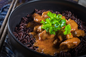Fototapeta premium Thai red curry with chicken and black rice.