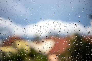 rain water drops on glass sky over old town background