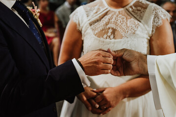 close up of two hands. Detail of the hands of a priest giving the ring to the groom in the middle of a religious marriage union ceremony