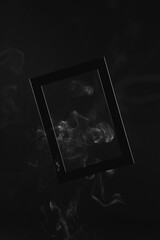 Black frame on a black monochrome background with white smoke around. Halloween background mock up