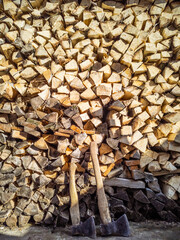Chopped firewood and two axes close up