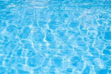 Fototapeta na wymiar Texture of water in pool. Closeup of rough water surface texture with splashes. Waving water texture backdrop