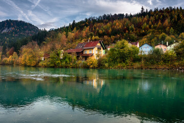 Fototapeta na wymiar Wonderful landscape of mountain village in fall. View of forest with yellowed foliage, which reflects in water. Fussen. Lech river. Bavaria. Germany.