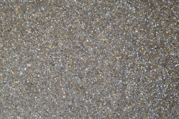 Pebble stones in a road for background. Grey picture with white and yellow spots