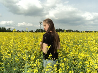 Young woman in the yellow rapeseed field