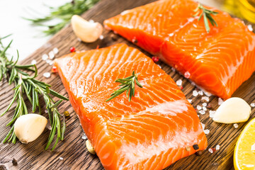 Salmon fish with ingredients at white table.