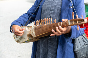 a man playing rabab traditional music instrument at a tourist place in pakistan