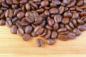 Naklejka premium Heap of Roasted Coffee Beans on Wooden Background