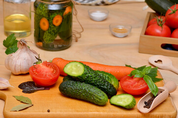 fresh vegetables cucumbers and tomatoes and garlic and seasonings on the board ingredients for canning