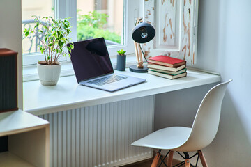 Cozy comfortable homely workplace by the window in a white interior