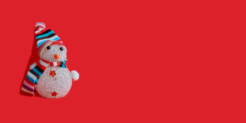 snowman in a striped hat and scarf on a red background. christmas decoration banner, horizontal, copy space, place for text. new year, holiday