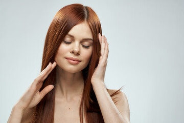Fototapeta premium Woman with beautiful long hair care nude shoulders cosmetics cropped view light background