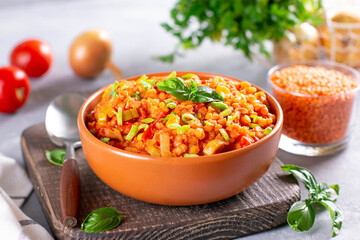 Soup with lentils, carrots, vegetables and basil, in a plate on a board. Indian vegetarian cuisine.
