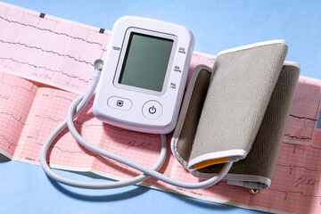 White modern electric tonometer on a cardiogram. Medicine concept.