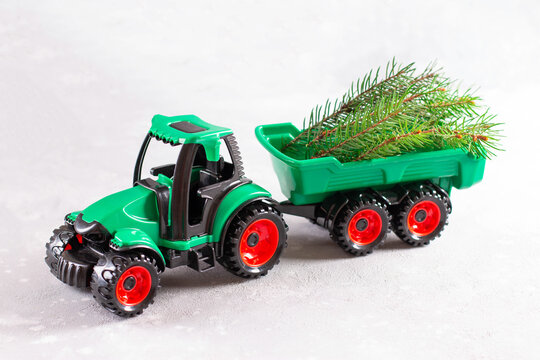 Tractor toy transporting branch of a Christmas tree