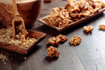 Walnuts in a wooden dish on an old wooden table.