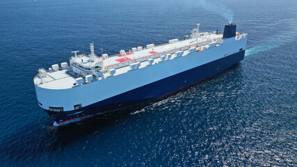 Naklejka premium Aerial drone photo of huge car carrier ship RO-RO (Roll on Roll off) cruising in Mediterranean deep blue Aegean sea