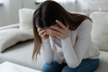 Unhappy young Caucasian woman feel distressed suffer from miscarriage or abortion alone at home....