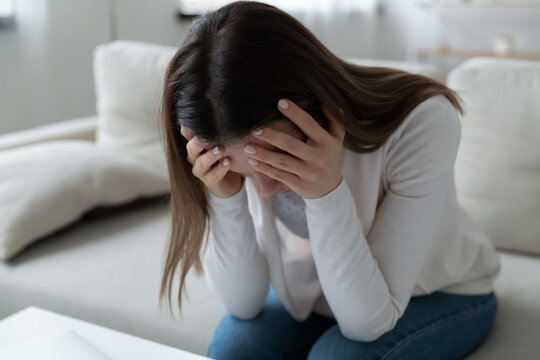 Unhappy young Caucasian woman feel distressed suffer from miscarriage or abortion alone at home. Upset sad lonely millennial female struggle with personal mental psychological problem, need help.
