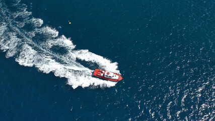 Aerial drone photo of red pilot boat cruising in high speed in Mediterranean deep blue sea offering navigational aid to ships - obrazy, fototapety, plakaty